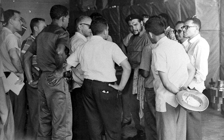 Ernesto Che Gueva en la fábrica de conservas de la Universidad Central de Las Villas. Ernesto Che Guevara escucha explicaciones del director de la fábrica de conservas de la Universidad Central Marta Abreu de Las Villas, en 1962.