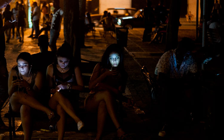 Jóvenes cubanos navegando por internet en zonas wifi. 