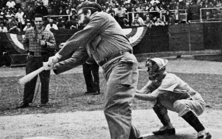 Fidel Castro batea y Germán Miranda actúa como receptor en la inauguración de la Primera Serie Nacional de Béisbol.