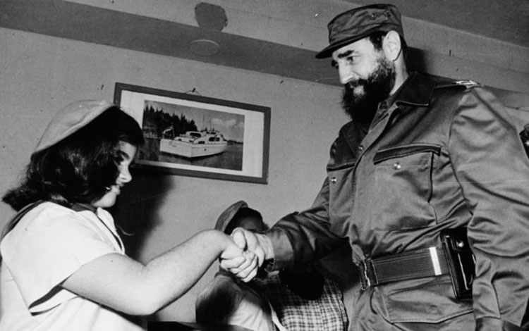 Fidel Castro Ruz saluda a una pionera tras votar en el referendo de 1976.