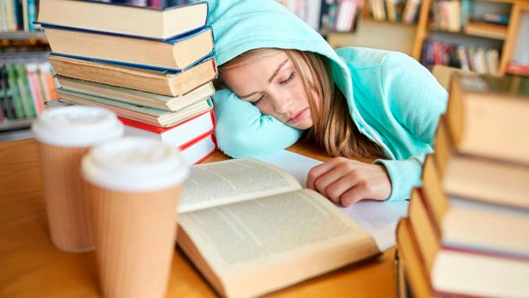 Estudiante dormida rodeada de libros. Estudiante dormida rodeada de libros.