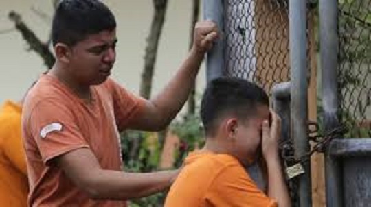 Niños ecuatorianos lloran por la muerte de su hermana.