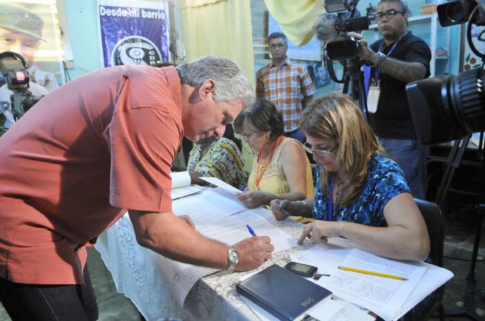 Miguel Dí­az Canel firma el registro para confirmar que ha ejercido su derecho al voto.