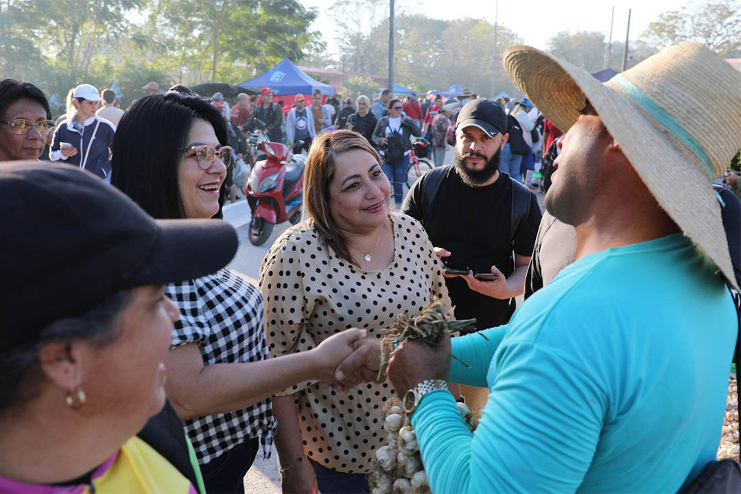 Primera secretaria del PCC y gobernadora de Villa Clara intercambia con vendedor en feria agropecuaria de fin de año.