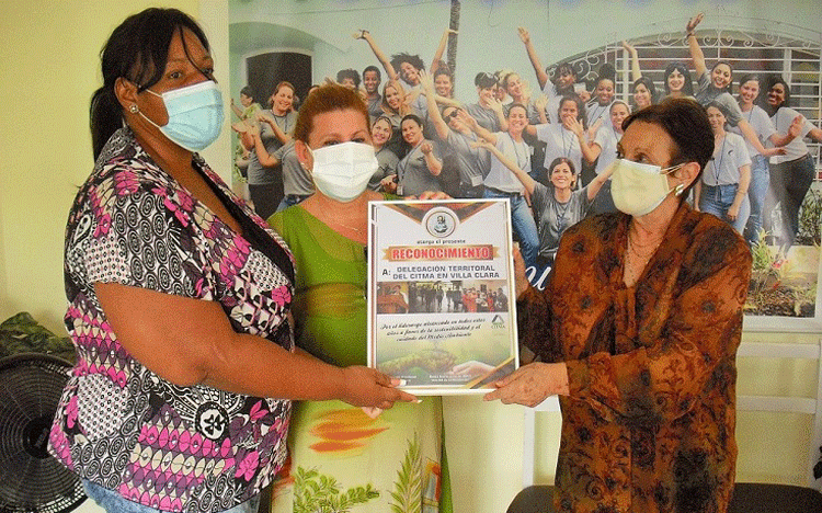 Keytia Bacallao Yera, integrante de la directiva provincial de la FMC, entregó un reconocimiento a la Dra. María del Carmen Velasco Gómez, directora del CITMA, y a Lourdes Castelo Valdés, al frente de la subdirección de Medio Ambiente, por todas las contribuciones de la colectividad científica a ese entorno que necesitamos.