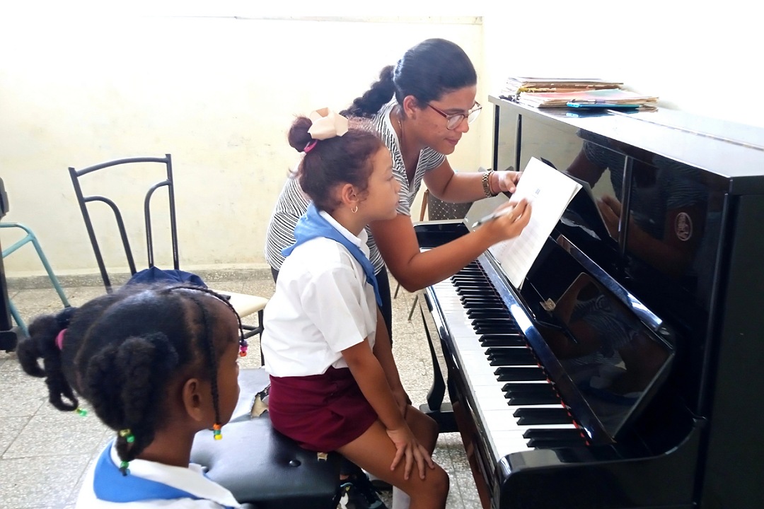 Alumnas y profesora de música en clases de piano.