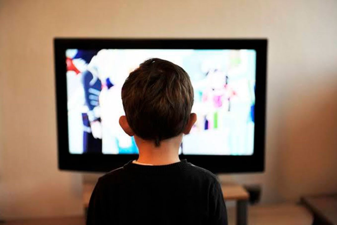NIño frente a la pantalla consumiendo un audiovisual.