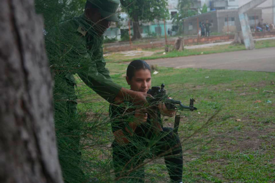 Joven estudiante recibe instrucciones sobre el uso del fusil.