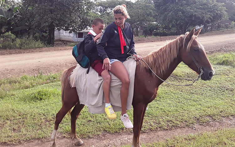 Madre con su hijo llegan a caballo a la escuela Alfredo Sáez Martí­n.