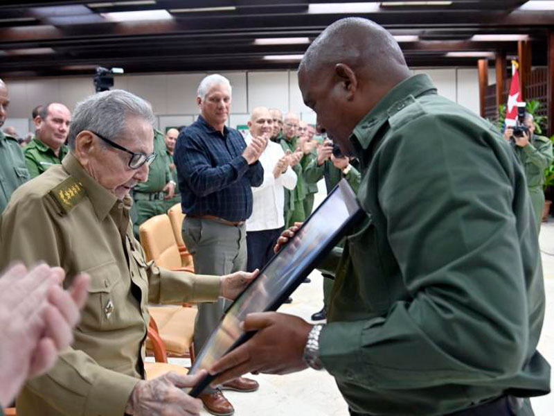 Raúl Castro entrega reconocimiento a combatiente.