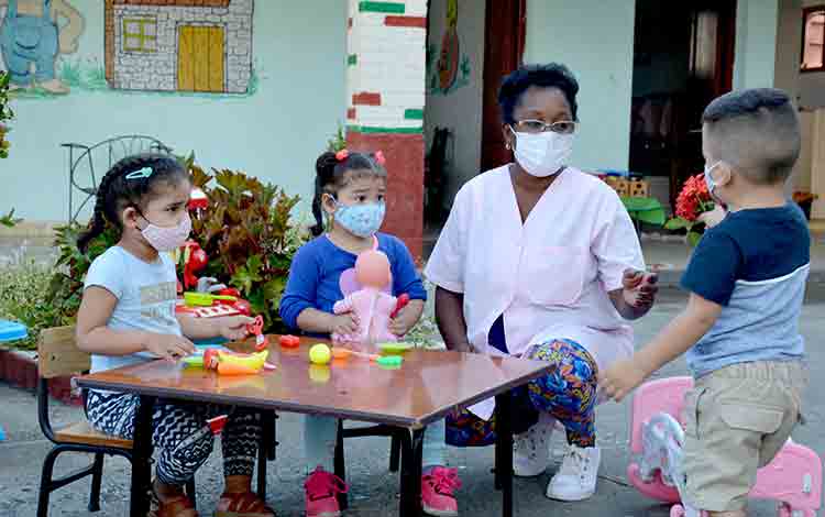 Educadora de círculo infantil con los niños.