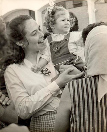 Vilma Espín Guillois carga una niña durante la inauguración de un círculo infantil en Cuba. Vilma Espín Guillois carga una niña durante la inauguración de un círculo infantil en Cuba.