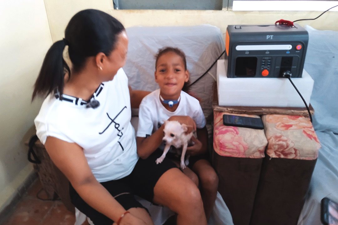 Paciente con su mamá en hogar beneficiado con sistema fotovoltaico.