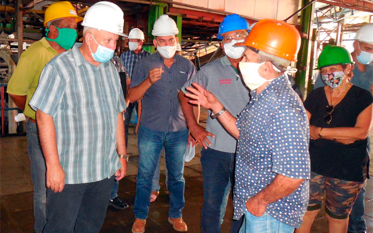 Tapia Fonseca (izquierda), escucha con atención al mecánico jubilado José Antonio Oliva Molina, que con 55 zafras en el ingenio «Carlos Baliño», todavía contribuye a garantizar labores de mantenimiento en la industria azucarera. (Foto Luis Machado Ordetx).