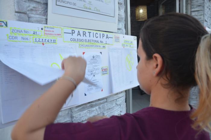 Joven cubana revisa la información electoral.