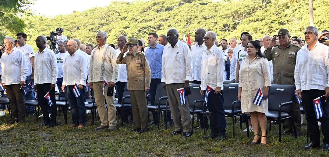 En Birán, tierra fértil de hombres hacedores de futuro, Cuba celebró este miércoles, como en cada palmo del país, el cumpleaños 99 del Comandante en Jefe, homenaje que marcó el inicio de una festividad mayor: el programa conmemorativo por el centenario de Fidel, que es, como diría el poeta, «eso que el árbol llama raíz».  La celebración en el conjunto histórico, al abrigo de un algarrobo frondoso y de los cedros que casi un siglo atrás cobijaron el nacimiento de un símbolo, estuvo presidida por otro hijo extraordinario de ese terruño holguinero, el más fidelista de todos los cubanos, su hermano de sangre e ideas, el General de Ejército Raúl Castro Ruz, líder al frente de la Revolución Cubana.  Junto a Raúl, en ese sitio que fue punto de partida en la historia patria, también estaba el Primer Secretario del Comité Central del Partido Comunista y Presidente de la República, Miguel Díaz-Canel Bermúdez; así como otros miembros del Buró Político, dirigentes del Partido, del Estado y del Gobierno, de la Unión de Jóvenes Comunistas, de las organizaciones de masas, de las Fuerzas Armadas Revolucionarias y del Ministerio del Interior, y una representación de jóvenes de las provincias de Santiago de Cuba, Guantánamo y Holguín.  Y de manera especial participó, en esta jornada de recordación, la brigada de solidaridad juvenil de varios países del mundo, cual reafirmación de que Cuba no está sola.  Con la certeza de que Fidel es un país y, más que evocarlo, toca traerlo al presente y continuar con hechos su legado, el miembro del Buró Político y secretario de Organización del Comité Central del Partido, Roberto Morales Ojeda, repasó la vida fecunda del Comandante, esa que comenzó a escribirse en el batey de Birán y que cambió para siempre el curso de la historia.  En sus palabras, aseguró que su probado sentido de justicia y cubanía germinó justamente en Birán, «donde nació para ser luz en tiempos oscuros, para ser voz de aquellos que no la tenían y esperanza de quienes, frente a la adversidad, solo podían aspirar a un mundo mejor. Su nacimiento significó el inicio de una vida consagrada a la lucha incansable por la libertad y la emancipación de Cuba».  Habló del estadista brillante, del amigo sincero, de su estatura universal, de los sentimientos de solidaridad que fomentó en nuestro pueblo, de su defensa de la paz y de todas las causas justas, del espíritu de resistencia y victoria que nos inculcó, y de la convicción profunda de salvaguardar la unidad como único camino para alcanzar la victoria.  Momento trascendental de su intervención fue la convocatoria al programa conmemorativo por el centenario del natalicio de Fidel, aprobado en el X Pleno del Comité Central del Partido, que tuvo lugar el pasado julio.  Se trata, dijo Morales Ojeda, de una celebración de respeto y compromiso, con la participación de todo el pueblo y marcado protagonismo de los jóvenes, y que pretende, en su esencia más profunda, potenciar el estudio de su obra, la investigación de su pensamiento y promover sus convicciones e ideales. Se trata de «convertir en actos concretos su enseñanza de que sí se puede».  El homenaje, al decir del dirigente partidista, emergerá en cada acción oportuna y solidaria que emprendamos, en cada avance de la ciencia, en cada obra cultural descolonizadora, cada hazaña deportiva o aporte a la producción; estará en nuestra capacidad de «encarnar, con ánimo crítico y creador, su espíritu transformador».  Honrarlo, afirmó, «es también hacer las cosas bien, desterrar la desidia, enfrentar los errores propios, siempre junto al pueblo y a los humildes para quienes se hizo esta Revolución».  Y allí, en la tierra que vio nacer al niño vigoroso, convertido después en paradigma para todos los tiempos, continuó el tributo con una obra hermosa de la compañía de teatro infantil La Colmenita, que fue a la esencia misma del líder, humano y sublime, vivo y presente.  Los pequeños recorrieron, con el lenguaje de la música y la poesía, la vida de Fidel, semilla de Revolución y triunfo, sueño de victoria cumplido.  A través de fragmentos del libro Todo el tiempo de los cedros, de la escritora Katiuska Blanco, los colmeneros dibujaron con palabras varios alumbramientos: el del amor entre Ángel y Lina, y el de sus hijos extraordinarios, llamados a conquistar la libertad definitiva de Cuba.  La obra resaltó el espíritu severo y a la vez sensible de Don Ángel, el vendaval que era Lina, su temple, y la infancia de Fidel entre personas humildes, esas con quienes otro cubano, también de talla de universal, juró antes echar su suerte.  Fidel, dijeron los niños, es la grandeza hecha hombre, la inteligencia inagotable, la conquista de todos los imposibles, el optimismo frente a la adversidad, el acompañamiento, el coraje y la resistencia de un pueblo, el impulso para hacer siempre el bien.  La puesta en escena fue, además, la certeza de aquellas palabras del Che, que el General de Ejército suscribió con hondura: «si nosotros estamos hoy aquí y la Revolución Cubana está aquí es, sencillamente, porque Fidel entró primero en el Moncada; porque bajó primero del Granma; porque estuvo primero en la Sierra; porque fue a Playa Girón en un tanque (…) porque tiene, como nadie en Cuba, la cualidad de tener todas las autoridades morales posibles para pedir cualquier sacrificio en nombre de la Revolución».  Luego de un largo aplauso, y de una exclamación que juntó todas las voces en un ¡Yo soy Fidel!, el General de Ejército y el Presidente Díaz-Canel fueron hasta el escenario para agradecerles a los niños «por un espectáculo tan revolucionario, tan bonito y tan simpático». Un abrazo a todos, dijo Raúl.  Este 13 de agosto, un país, que es la casa de todos, estuvo de cumpleaños, y sus hijos le cantaron a Fidel, conscientes de que el mejor homenaje es defender a Cuba, a lo que dedicó todas sus energías; es quererla bien, es hacer cada cual su parte del deber; es sostener y continuar la Revolución; es nunca claudicar.  El mejor homenaje a Fidel es vencer.