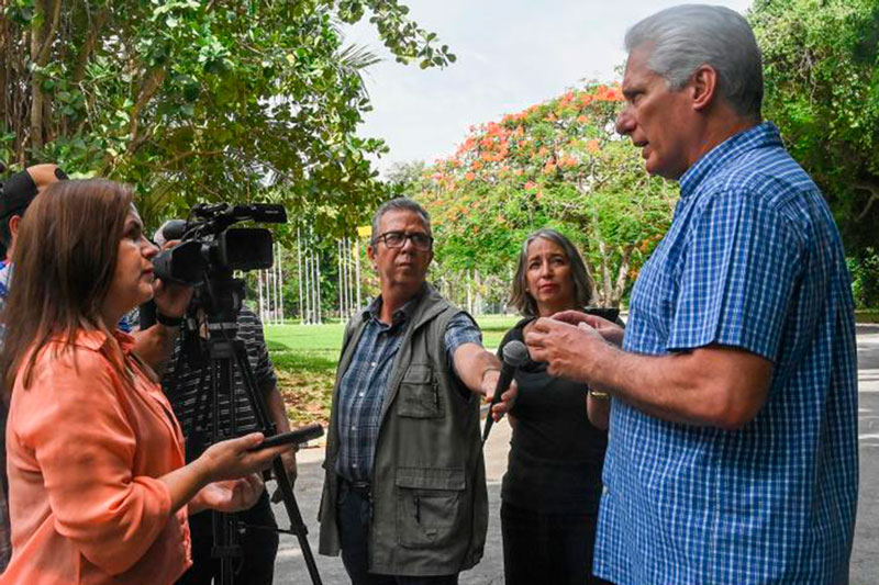 Presidente cubano y equipo de prensa.