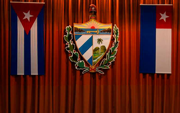 Banderas y escudo en el escenario de la Asamblea Nacional.