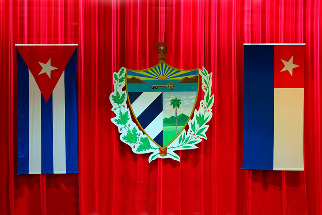 Banderas y escudo en el escenario de la Asamblea Nacional.