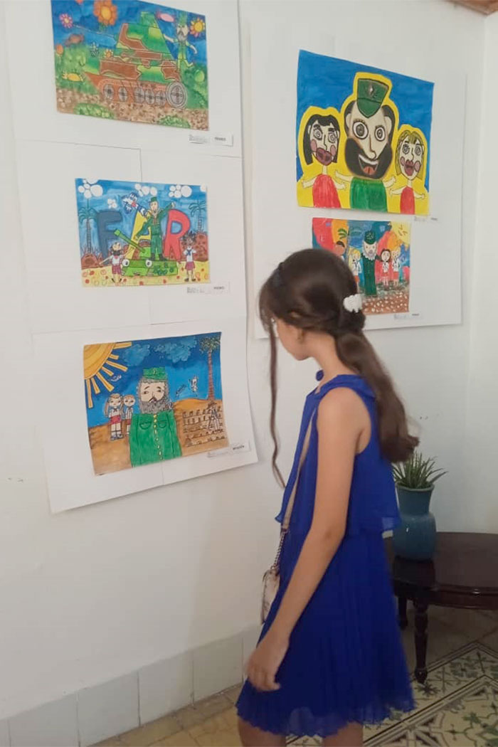 Niña aprecia las obras.