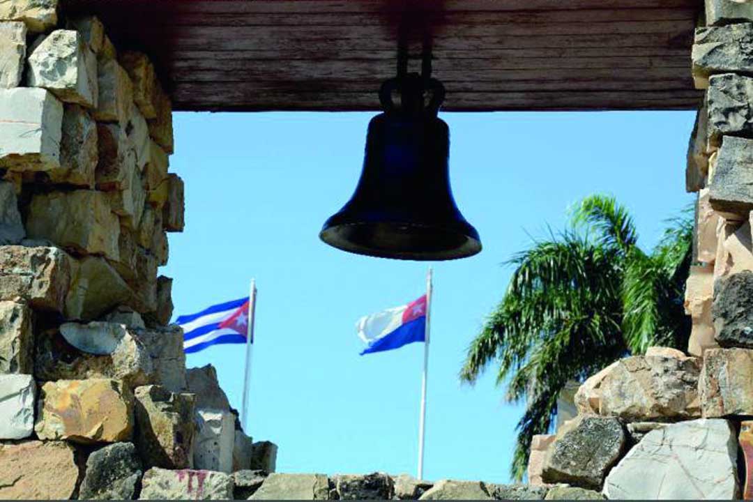 Campana de La Demajagua y banderas cubana y de Céspedes