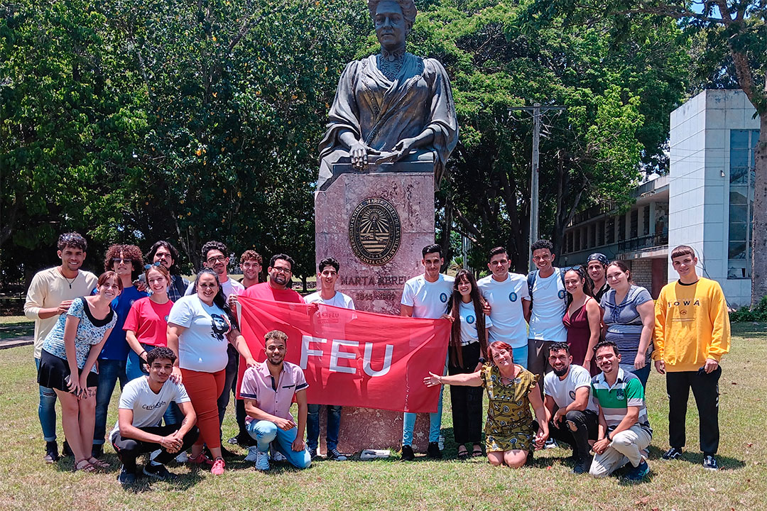 Miembros del consejo nacional de la FEU y estudiantes de la UCLV ante la estadua de Marta Abreu en el centro de altos estudios.