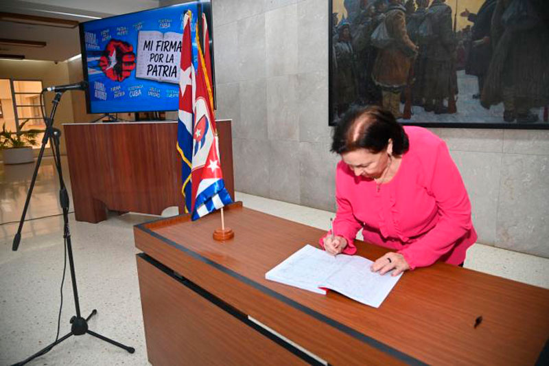 Trabajadora del Comité Central firma el documento Mi firma por la Patria.