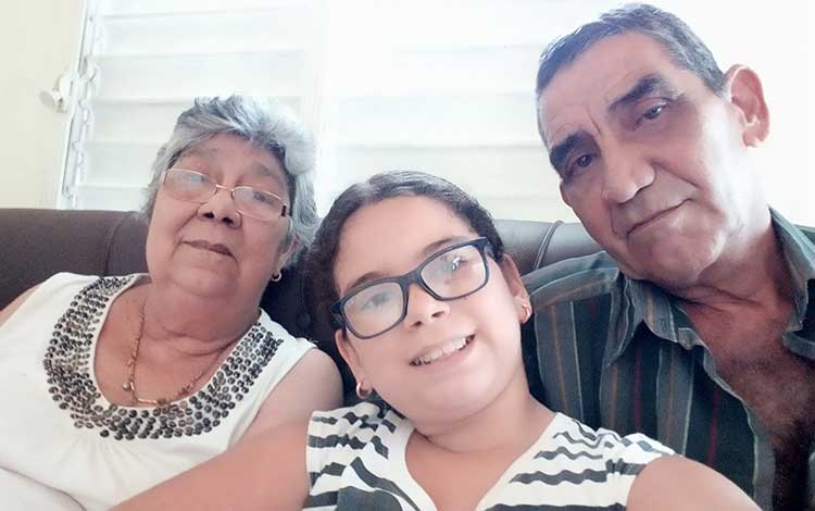 Periodista Mercedes Rodríguez García junto a su esposo y su nieta.