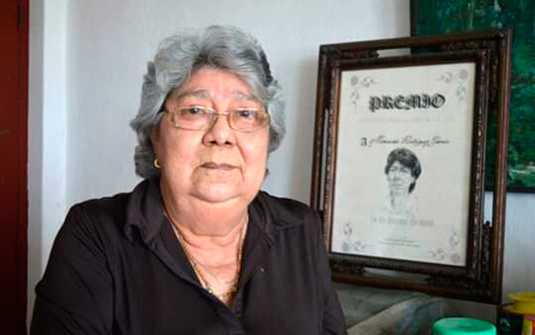 Mercedes Rodrí­guez Garcí­a junto al cuadro con uno de sus tantos premios periodí­sticos.