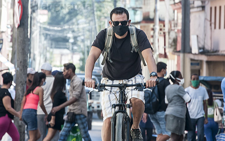 Joven con nasobuco en bicicleta.