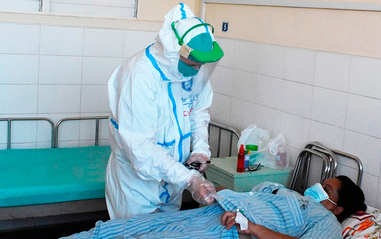 Doctor Yoan Pérez Ojeda, jefe de los Servicios Internos del hospital militar Comandante Manuel Fajardo Rivero, en Villa Clara, atiende a paciente de COVID-19.