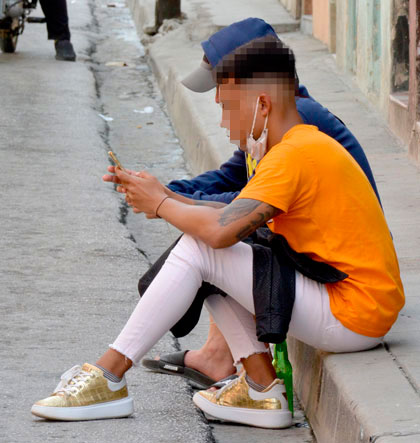 Joven sentado en un acera de Santa Clara y con el nasobuco retirado. Joven sentado en un acera de Santa Clara y con el nasobuco retirado.