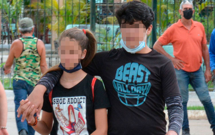 Pareja de jóvenes que no usa correctamente el nasobuco.