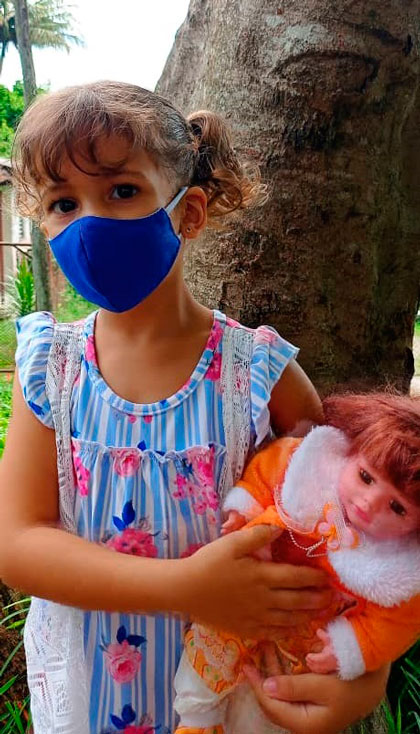 Niña protegida con nasobuco. Niña protegida con nasobuco.