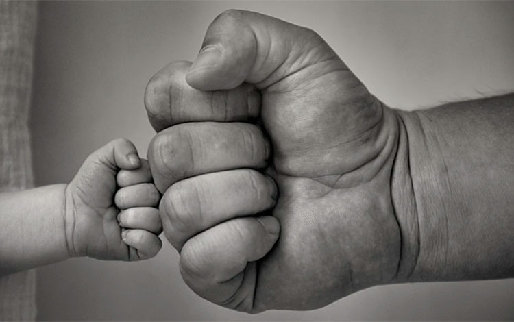 Saludo con el puño entre un hijo y un padre.