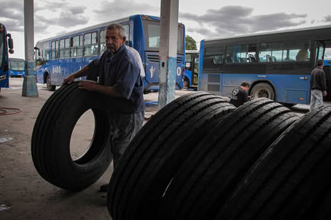 Trabajador del transporte colocando gomas nuevas