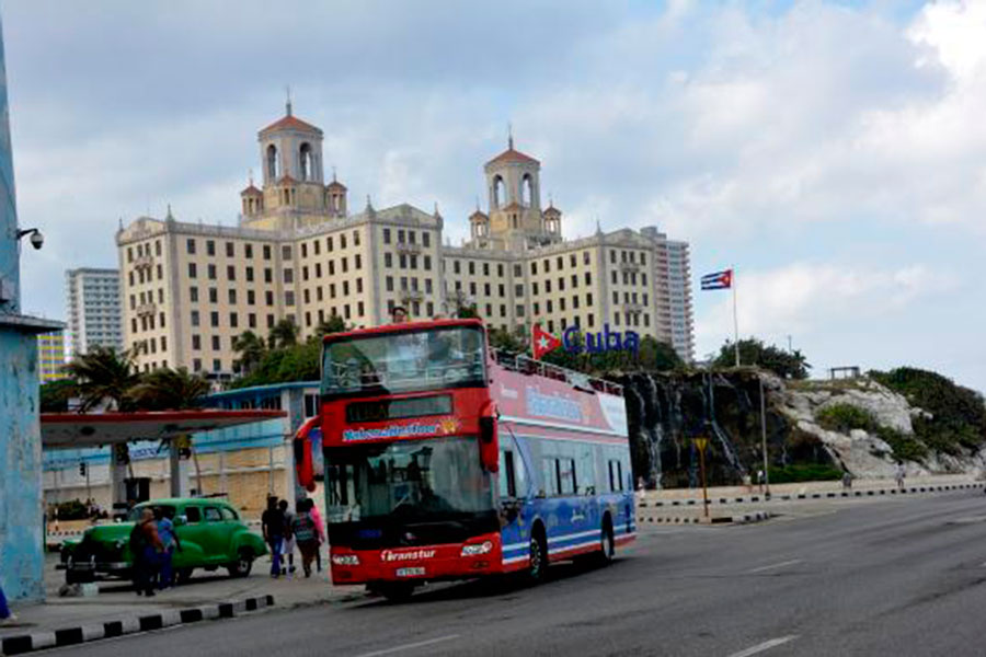 Guagua de turismo y hotel Nacional al fondo.
